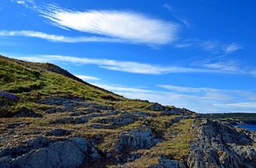 low angle view towards a steep hillside, blue sky in the background, Killick Coast NL Canada