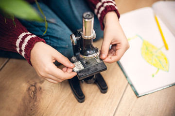 Hands  of little boy using microscope on biology lesson