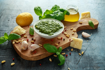 Green Basil Pesto with parmesan cheese, pine nuts, garlic and lemon on wooden board