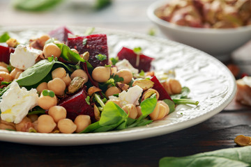 Healthy Beet Salad with chickpeas, pistachios nuts, feta cheese on rustic wooden background