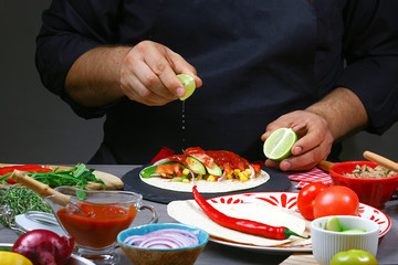 Lemon splash in chef hand under mexican burito. Cook preparing delicious mexican burito at kitchen. Tasty mexican cuisine