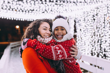 Little black girl enjoying in ice skating with her mother.