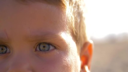 4K Slow motion - Caucasian Child with blue eyes looking at the camera in a sunny day