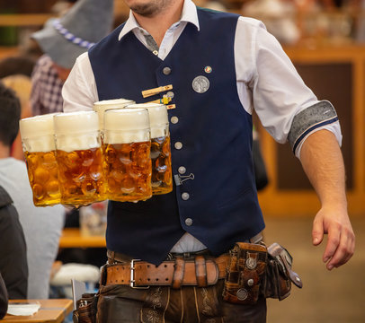 Oktoberfest, Munich, Germany. Waiter serving beers, closeup view