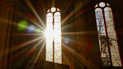 Sonnenstrahlen scheinen durch ein altes Kirchenfenster