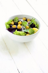 Healthy salad with chickpeas, beets, greens mix and yogurt-garlic sauce, vertical 