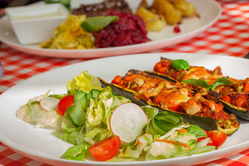 Healthy dinner plate - Zucchini stuffed vegetables and salad - letuce with cherry tomatoes, radish and cucumber