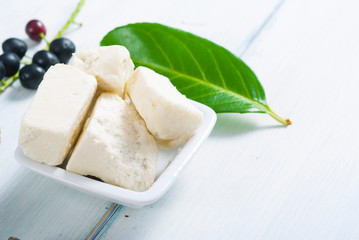 cosmetic clay, soaps, henna blocks, sponge and moisturizer on white wood table