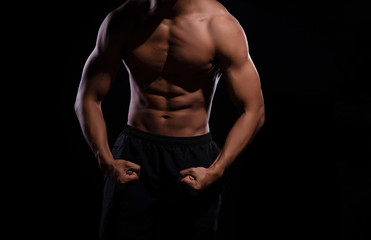 Fototapeta na wymiar The human with muscular torso on black background,show fit and firm body,strong muscle