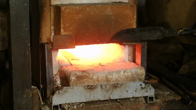 Making the knife out of metal at the forge. Heating of metal billets in the furnace.