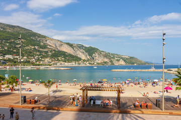 Shoreline in Menton in France with bather in summer season