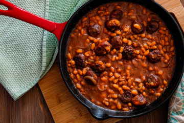 beans with sausage on a cast iron skillet