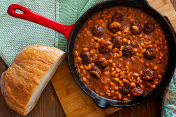 beans with sausage on a cast iron skillet