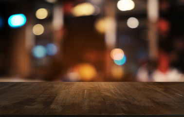 Empty dark wooden table in front of abstract blurred bokeh background of restaurant . can be used for display or montage your products.Mock up for space.