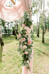 Beautiful flowers and roses of pastel color on a wedding arch.