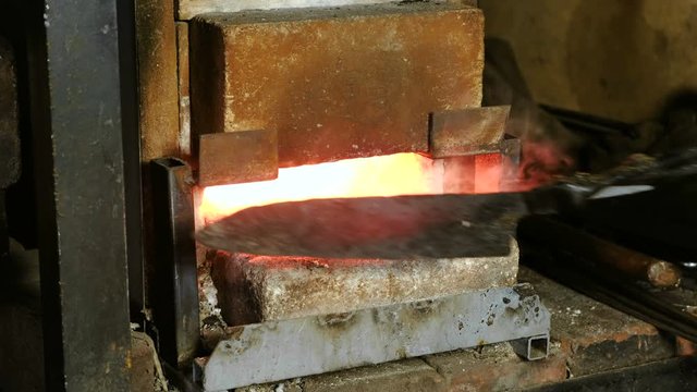 Making the knife out of metal at the forge. Heating of metal billets in the furnace.