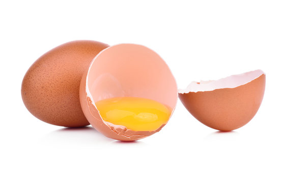 Broken egg in eggshell half and raw egg isolated on white background