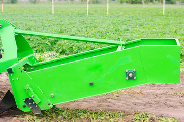 tractor in the field with a plow for digging potatoes harvesting, seasonal work, fresh vegetables,...