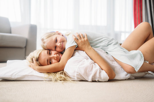 Mother and child play together lying on the floor