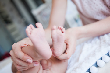 Obraz na płótnie Canvas Newborn baby hands and legs mother hands