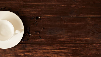 empty white cup with coffee beans on a dark wooden table background