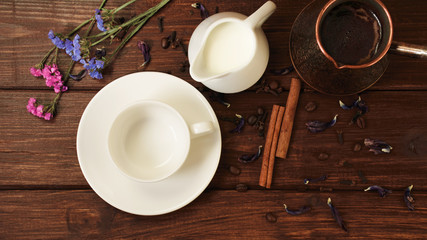 cup, milk, turk fresh coffee with cinnamon flowers on a dark wooden table 