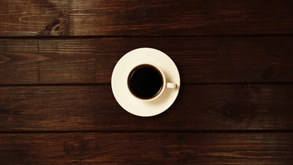 Cup of coffee on wooden table top view