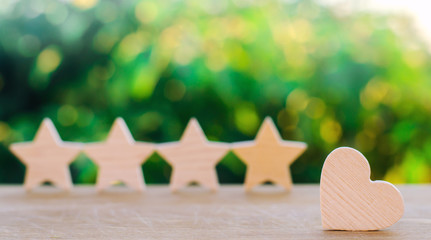 four stars and heart on a green bokeh background. rating five stars, the choice of the editorial office and the buyer. concept of rating, review. quality, service. selective focus