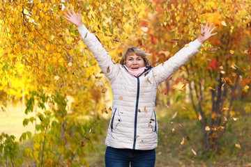 Portrait middle aged woman in autumn park