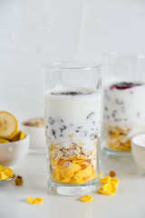 Breakfast in glass Cup: homemade granola, banana, fresh berries, yogurt on white background. The concept of healthy eating, high-carbon Breakfast.