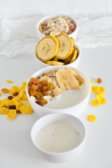 Breakfast in glass Cup: homemade granola, banana, fresh berries, yogurt on white background. The concept of healthy eating, high-carbon Breakfast.