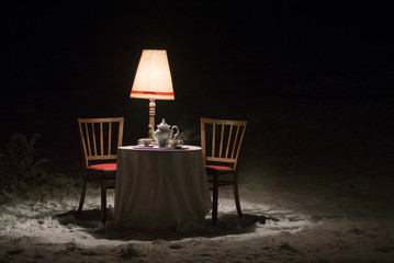 Surreal scene outside the winter garden - diner with a porcelain tea service set