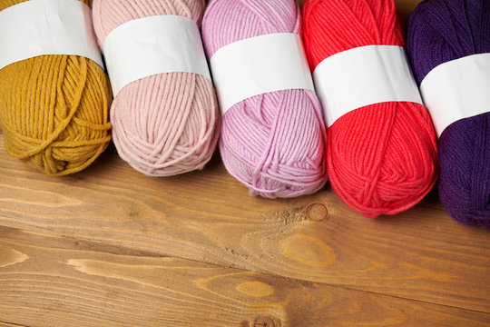 colorful wool yarn for knitting on wooden background