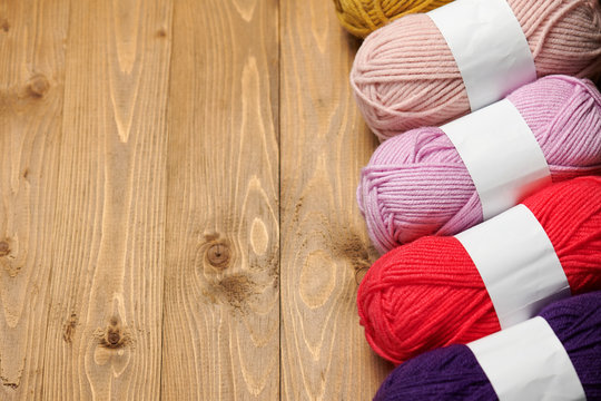 colorful wool yarn for knitting on wooden background
