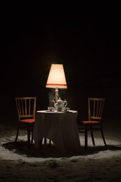 Surreal scene outside the winter garden - diner with a porcelain tea service set