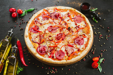 Delicious classic meat pizza on black background