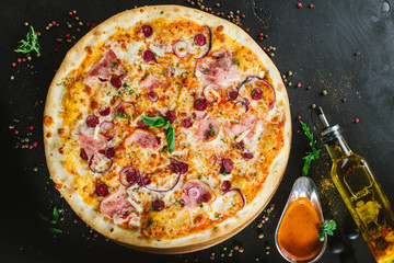 Delicious classic meat pizza on black background