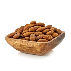 Almonds pile in wooden bowl from top view isolated on white background