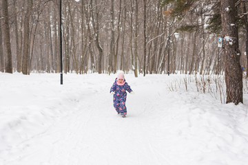 Family, children and nature concept - Beautiful little child girl have fun in winter park
