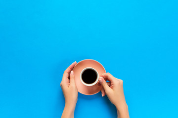 Fototapeta na wymiar Minimalistic style woman hand holding a cup of coffee on background. Flat lay, top view