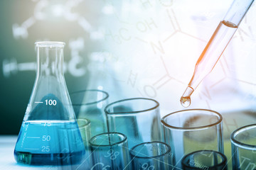 Naklejka premium Dropping chemical liquid to test tube with lab glassware, science or chemistry research and development concept 