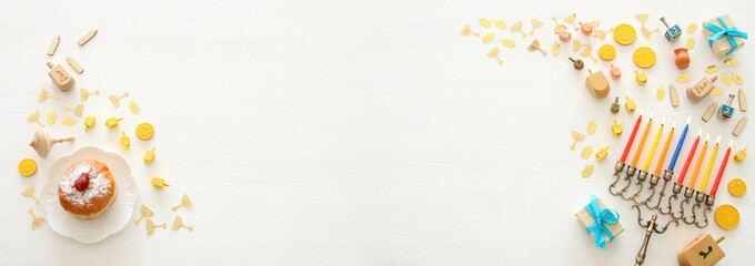 Banner of jewish holiday Hanukkah background with traditional spinnig top, menorah (traditional candelabra) and burning candles.