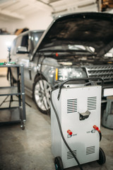 Car with opened hood and charging station