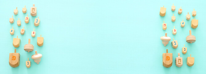 Image of jewish holiday Hanukkah with wooden dreidels colection (spinning top) over mint background.