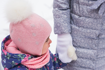 Winter, family and people concept - Close up of young mother is walking with her daughter in winter forest.