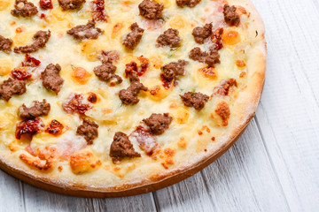 Minced meat tomato red onion pizza on a wood background. toning