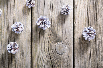 white painted pine cones Christmas decoration on old rustic wood table background