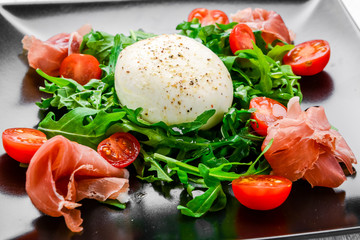 Salad from arugula, egg poached and a hamon