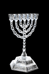 Happy Hanukkah and winter holidays concept with a silver menorah isolated on black background
