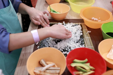 Cook spreading rice over nori